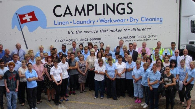 A group of people standing in front of a laundry truck.