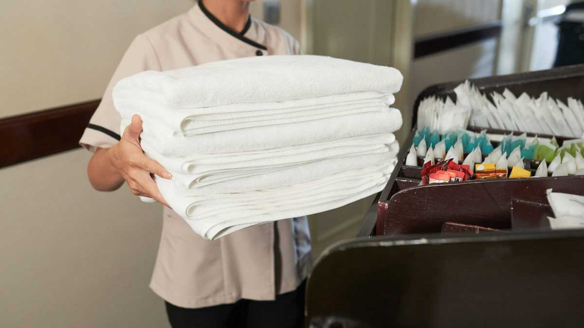 chambermaid with pile of fresh towels