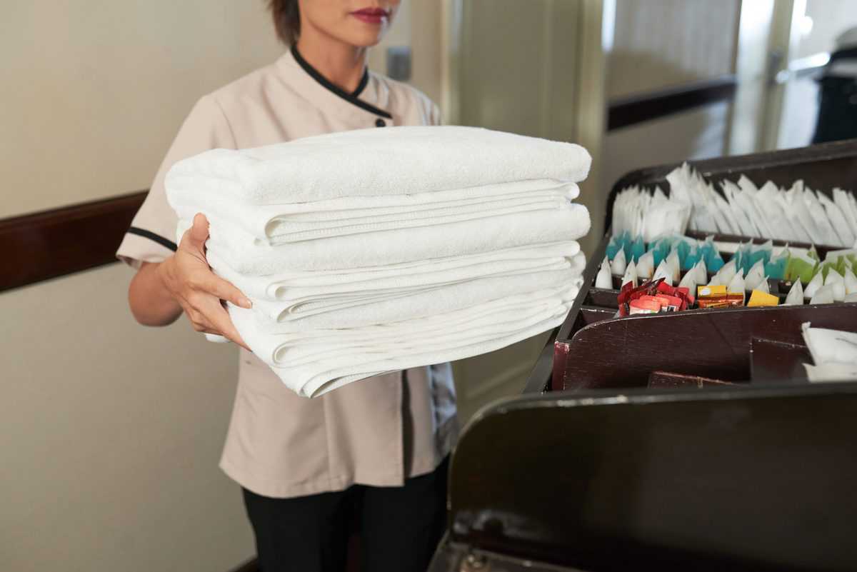 chambermaid with pile of fresh towels