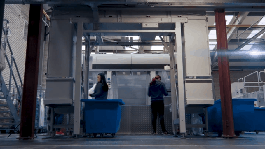 A person is standing in a warehouse with a lot of boxes.